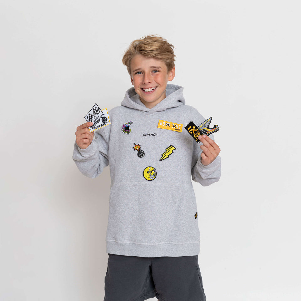 Kinder Hoodie Farbe grau mit schwarzem Logo an Kindermodel mit Patches
